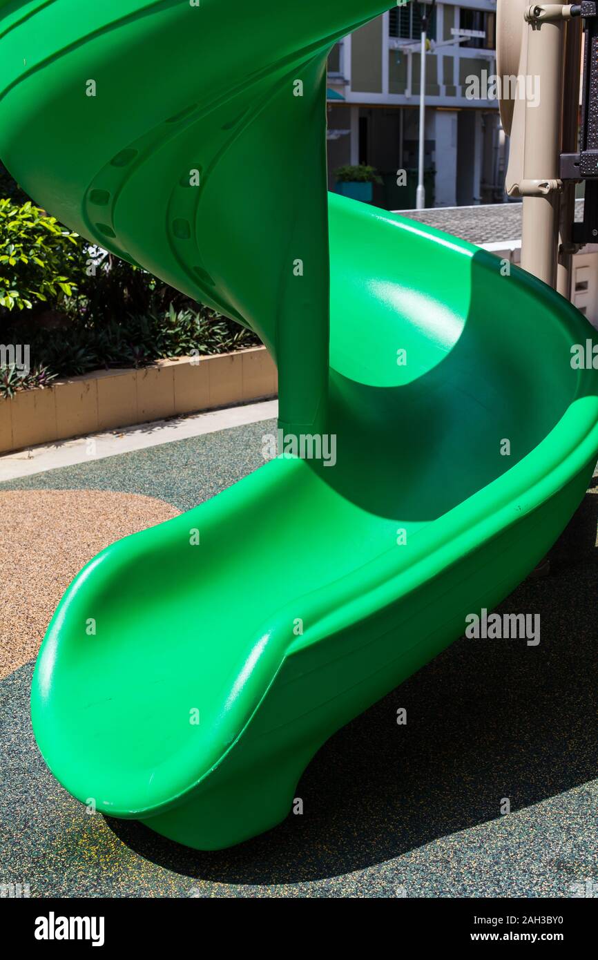 Nahaufnahme vertikalen Bild eines Spielplatzes Kinder grüne Farbe Rutsche bei sonnigem Outdoor Stockfoto