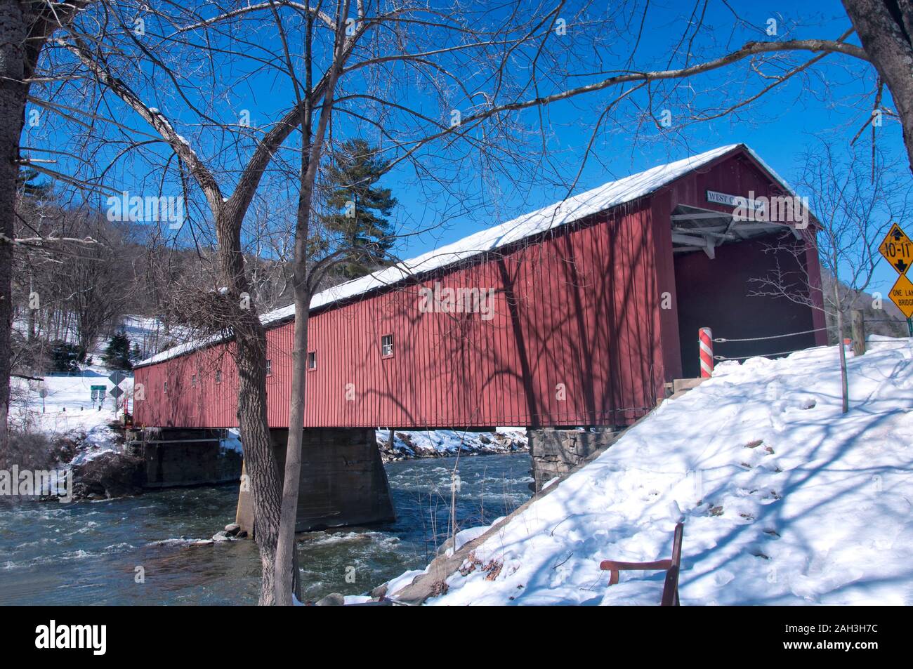 Die schneebedeckten Sehenswürdigkeiten West Cornwall Brücke überspannt den Housatonic River an einem sonnigen Wintertag in Connecticut abgedeckt. Stockfoto