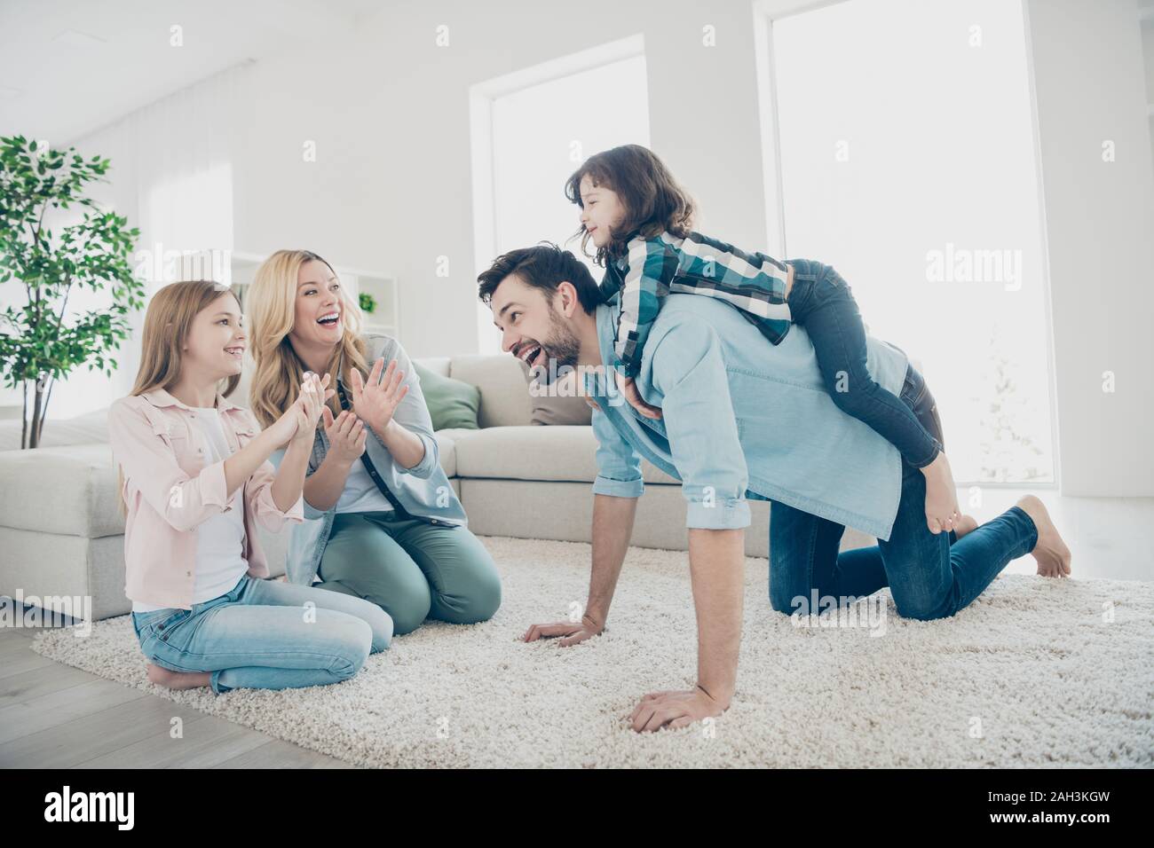 Profil Foto von vier Mitglieder der Familie sitzen, flauschigen Teppich spielerische gemütliche Apartments im Innenbereich Stockfoto