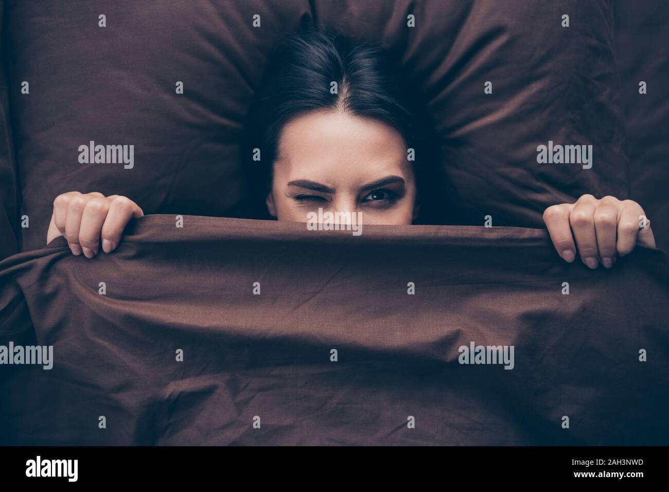 Close-up Portrait von ihr, daß sie schön - Attraktive schön Heiter Heiter lustig kindisch mädchenhafte Mädchen zu verstecken Gesicht maroon Schleier im Bett lag, auf der Suche Stockfoto