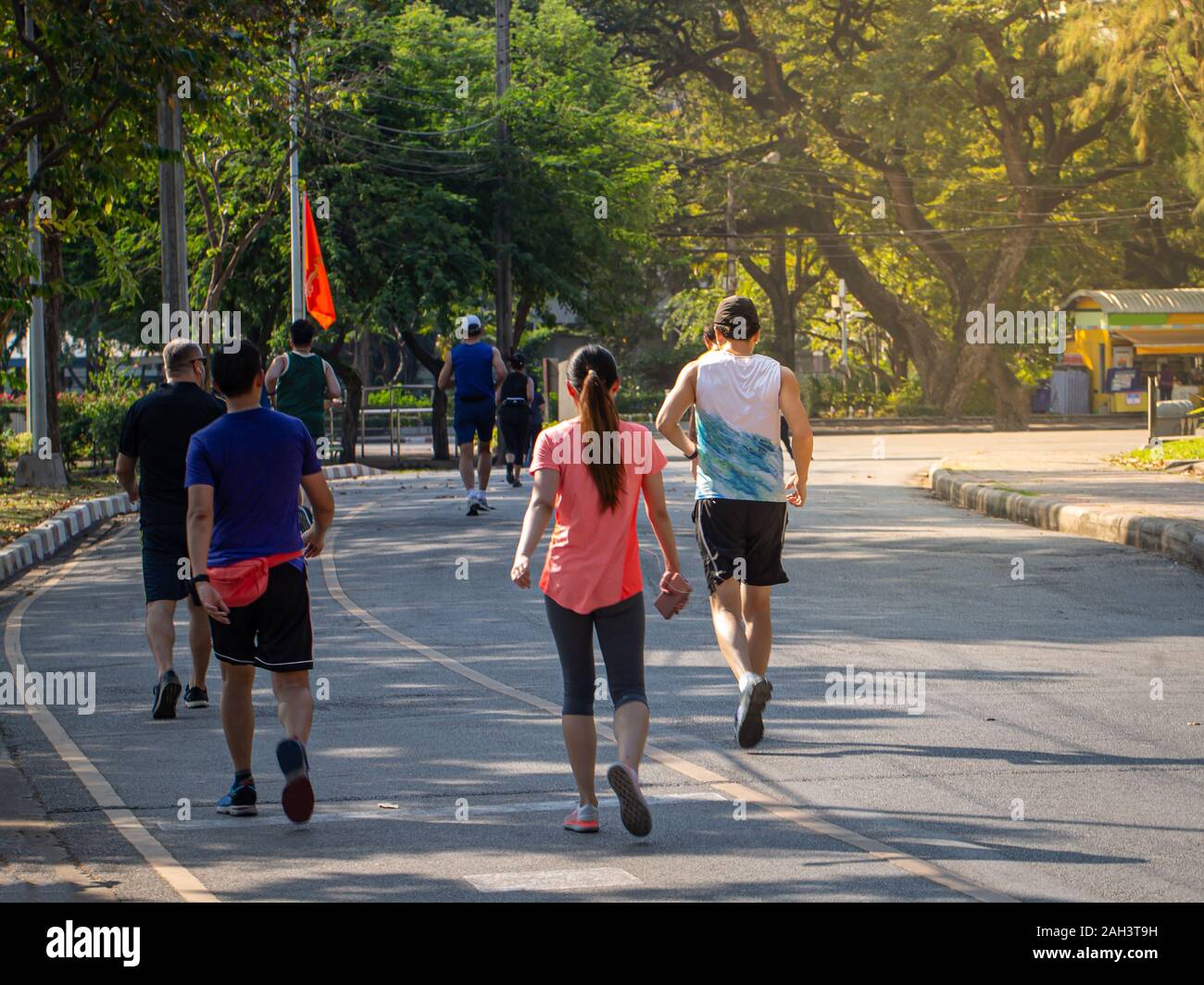 Gesunde Gruppe von Menschen Jogging und Walking auf der Straße in Park Stockfoto