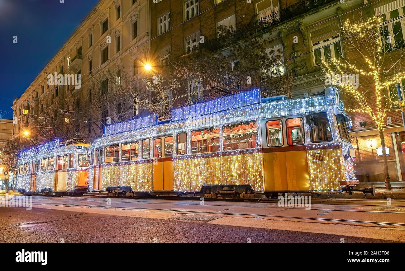 Festlich licht Straßenbahn (fenyvillamos) bei Nacht eingerichtet. Weihnachtszeit in Budapest. Vintage Tram vom Stadtzentrum Budapest mit Weihnachtsbeleuchtung dekoriert Stockfoto