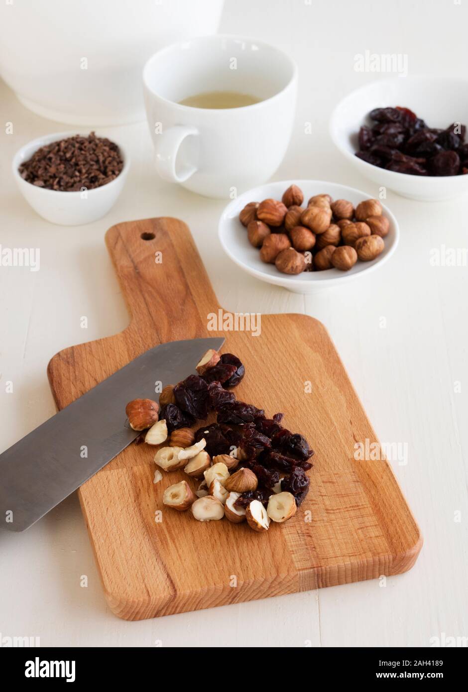 Schneidbrett mit getrockneten Kirschen und Haselnüsse für Müsli gehackt Stockfoto