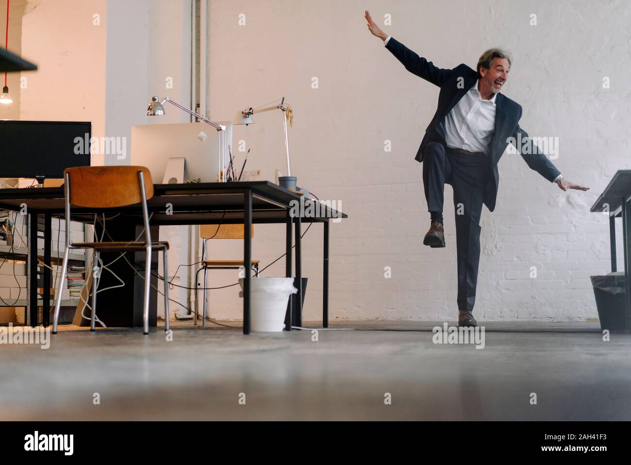Gerne älteren Geschäftsmann Gymnastik im Büro Stockfoto