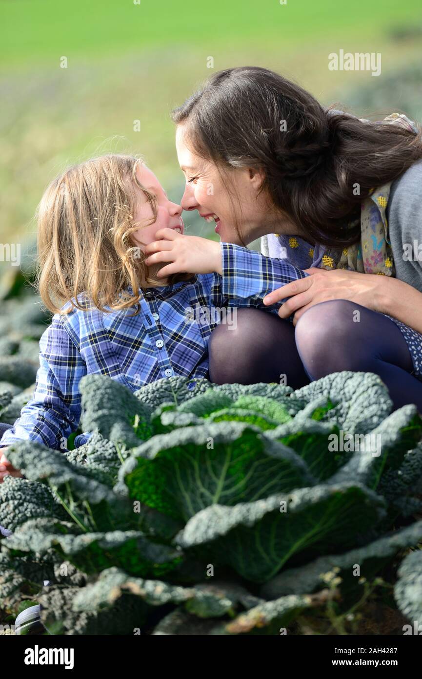 Mutter mit Tochter in einem Savoy Feld, Nase an Nase Stockfoto