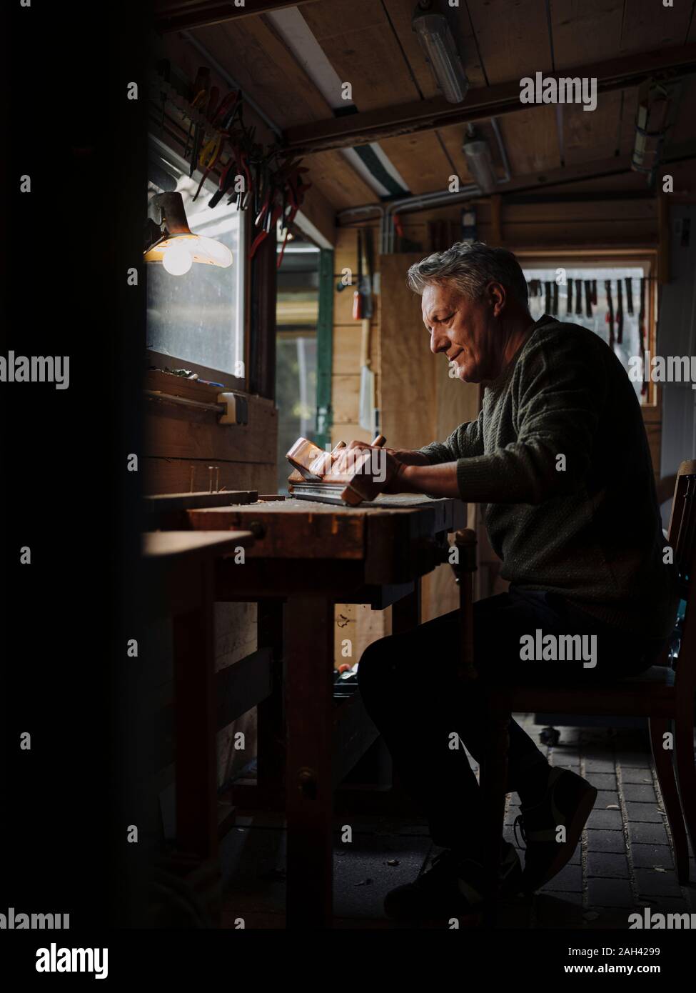 Älterer Mann an der flexiblen Leitung Holz in der Werkstatt Stockfoto
