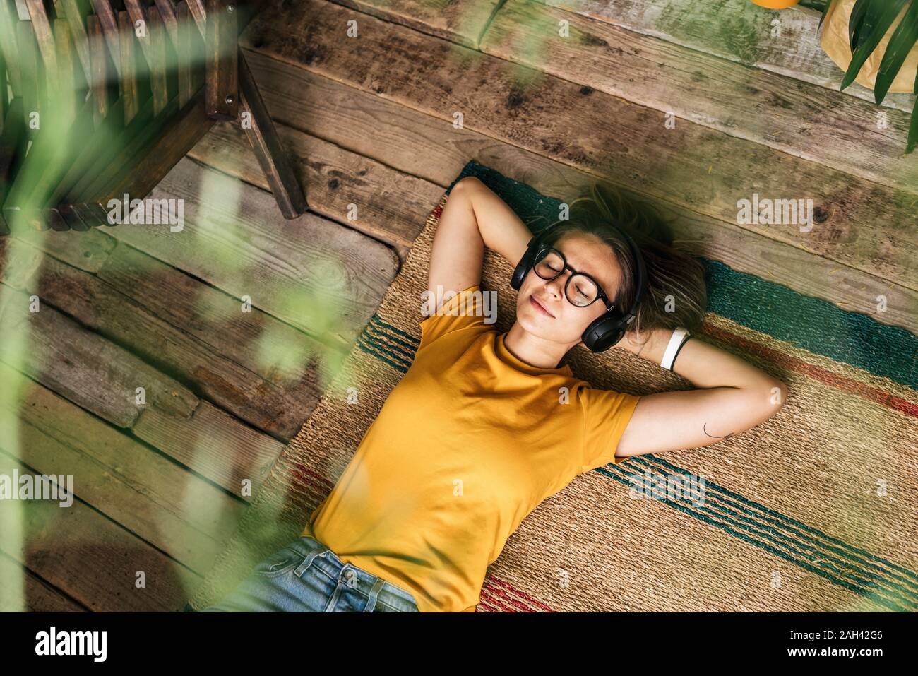 Entspannt junge Frau auf dem Boden liegend zu Hause Musik hören Stockfoto