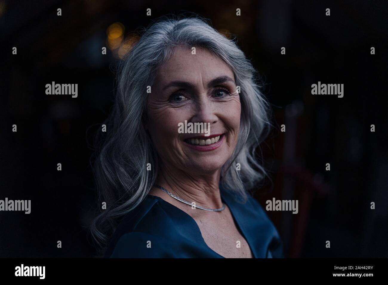 Porträt eines lächelnden reife Frau draußen in der Nacht Stockfoto