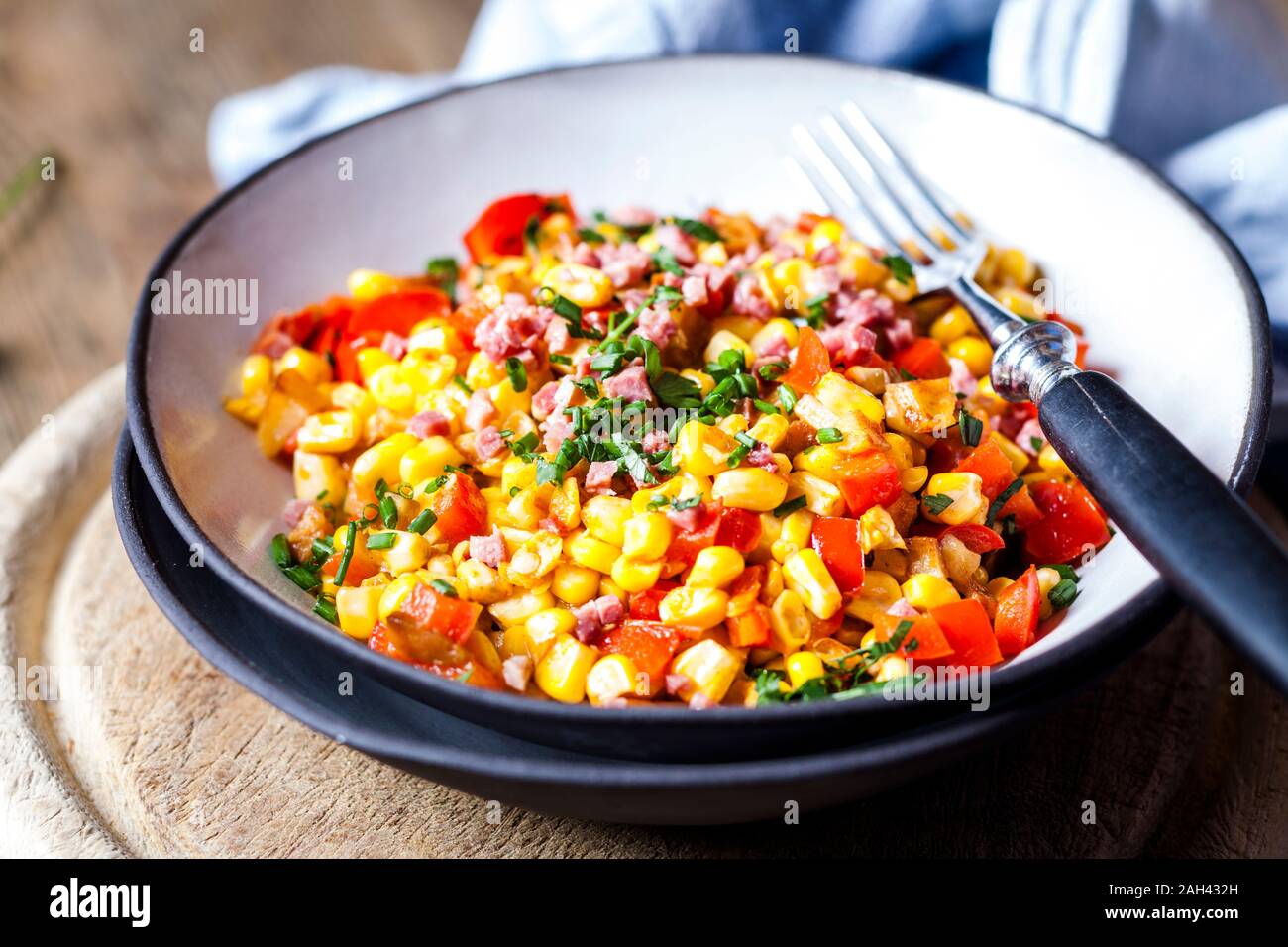 Schüssel mit warmem Mais Salat mit Paprika, Kartoffeln und gewürfelten Schinken Stockfoto