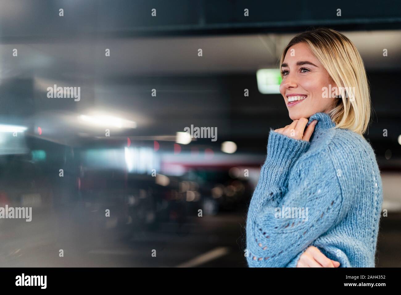 Porträt eines lächelnden jungen Frau in einer Parkgarage Stockfoto