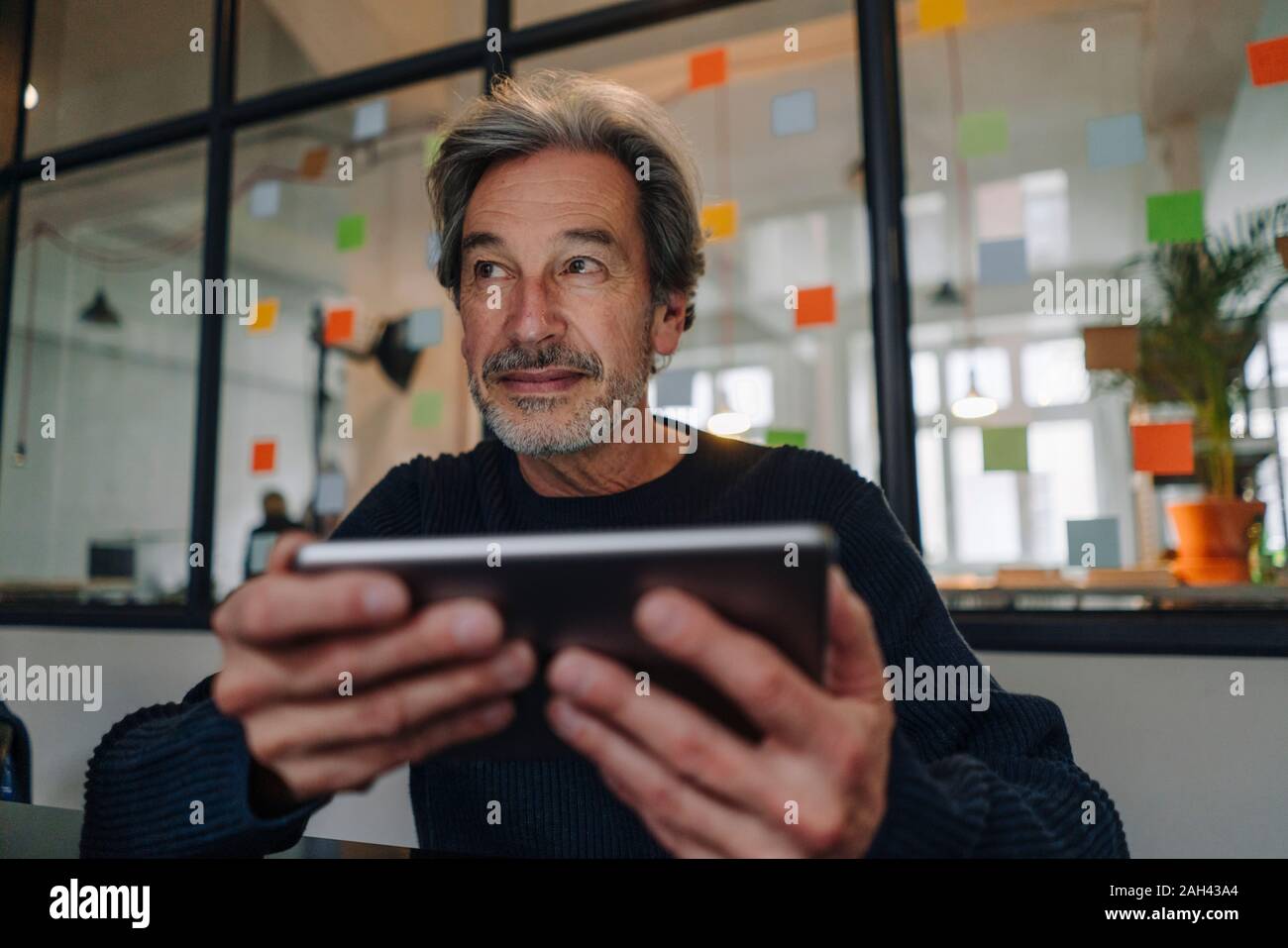 Senior Geschäftsmann mit Tablet-PC im Büro Stockfoto