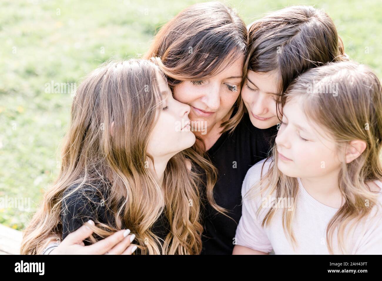 Glückliche Mutter mit drei Triplet Töchter auf einer Wiese Stockfoto