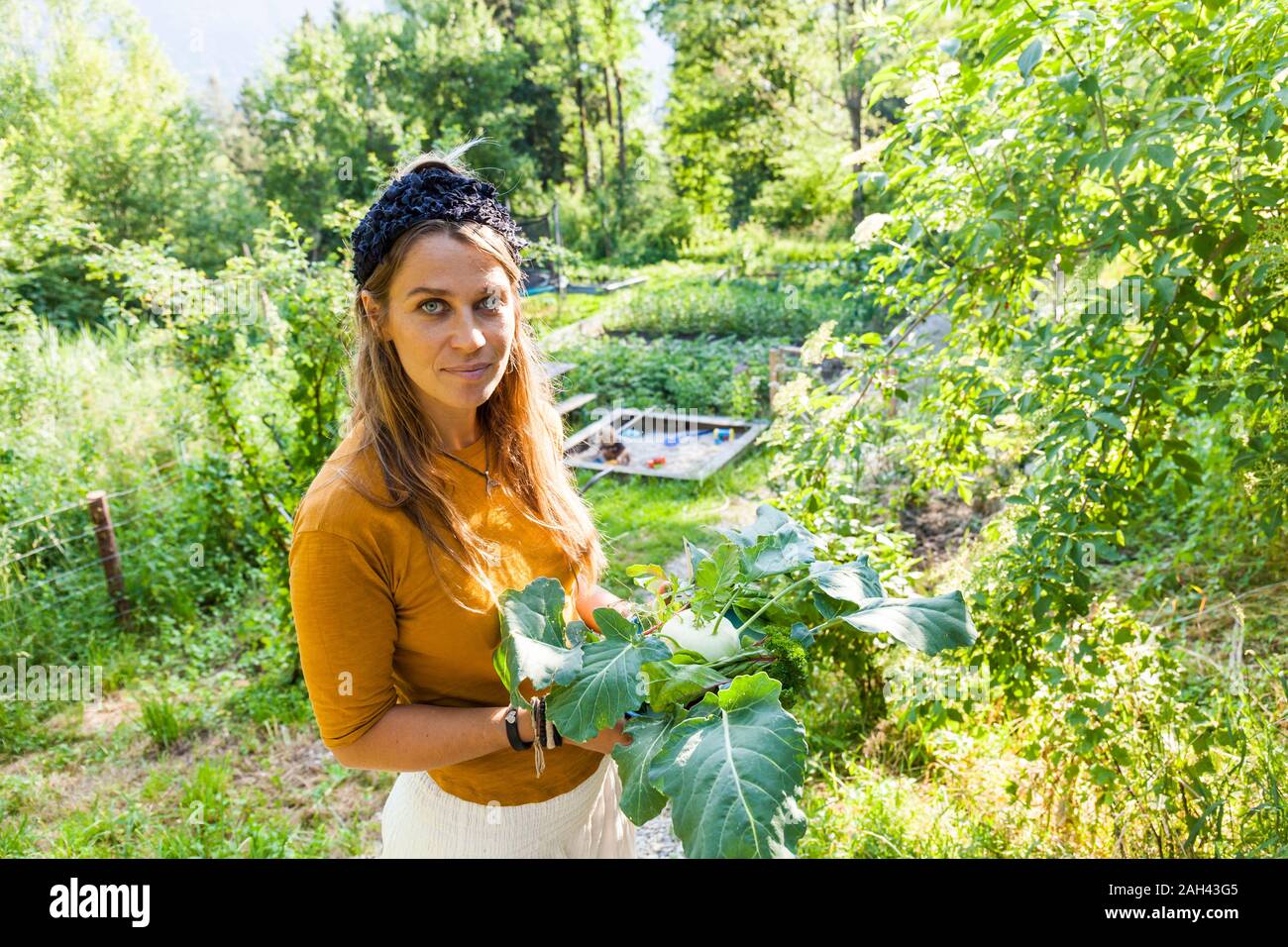 Frau, Gartenarbeit, Kind in Sandbox Stockfoto