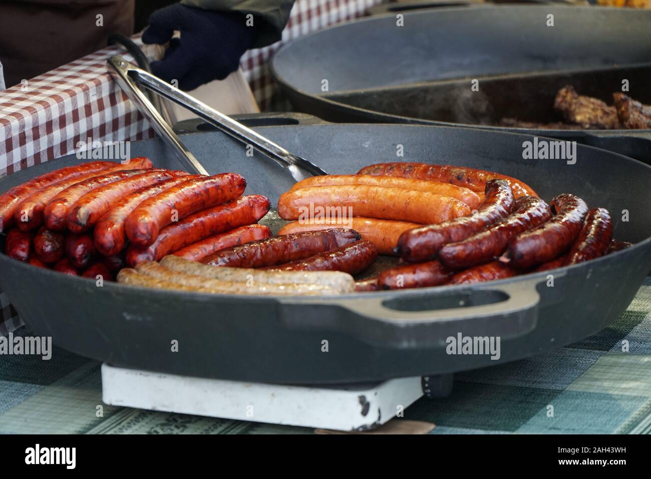 Prag, Tschechische Republik 2019: Traditionelle Hot dog Vorbereitung auf die Kohle Feuer auf der Straße während des Weihnachtsmarktes Stockfoto