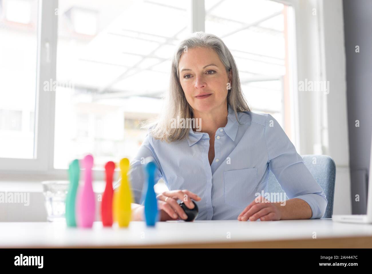 Reife Geschäftsfrau Spielen mit Stiften auf dem Schreibtisch im Büro Stockfoto