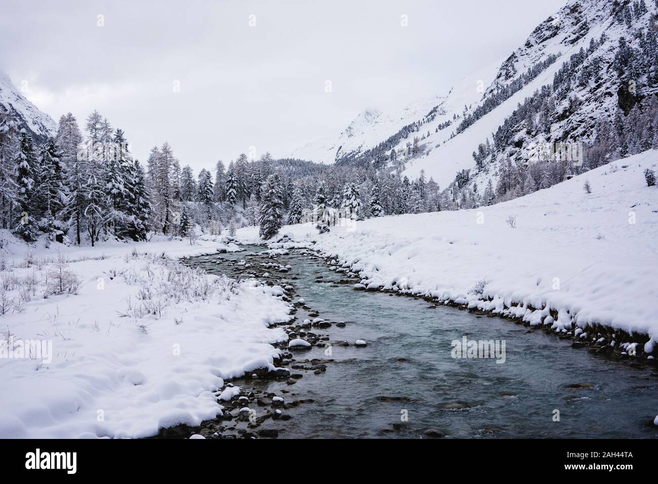 Verschneite Berglandschaft mit Fluss, Engadin, Schweiz Stockfoto