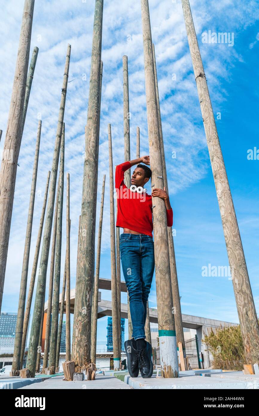 Junge Mann auf Zehenspitzen zwischen Holzpfähle Stockfoto