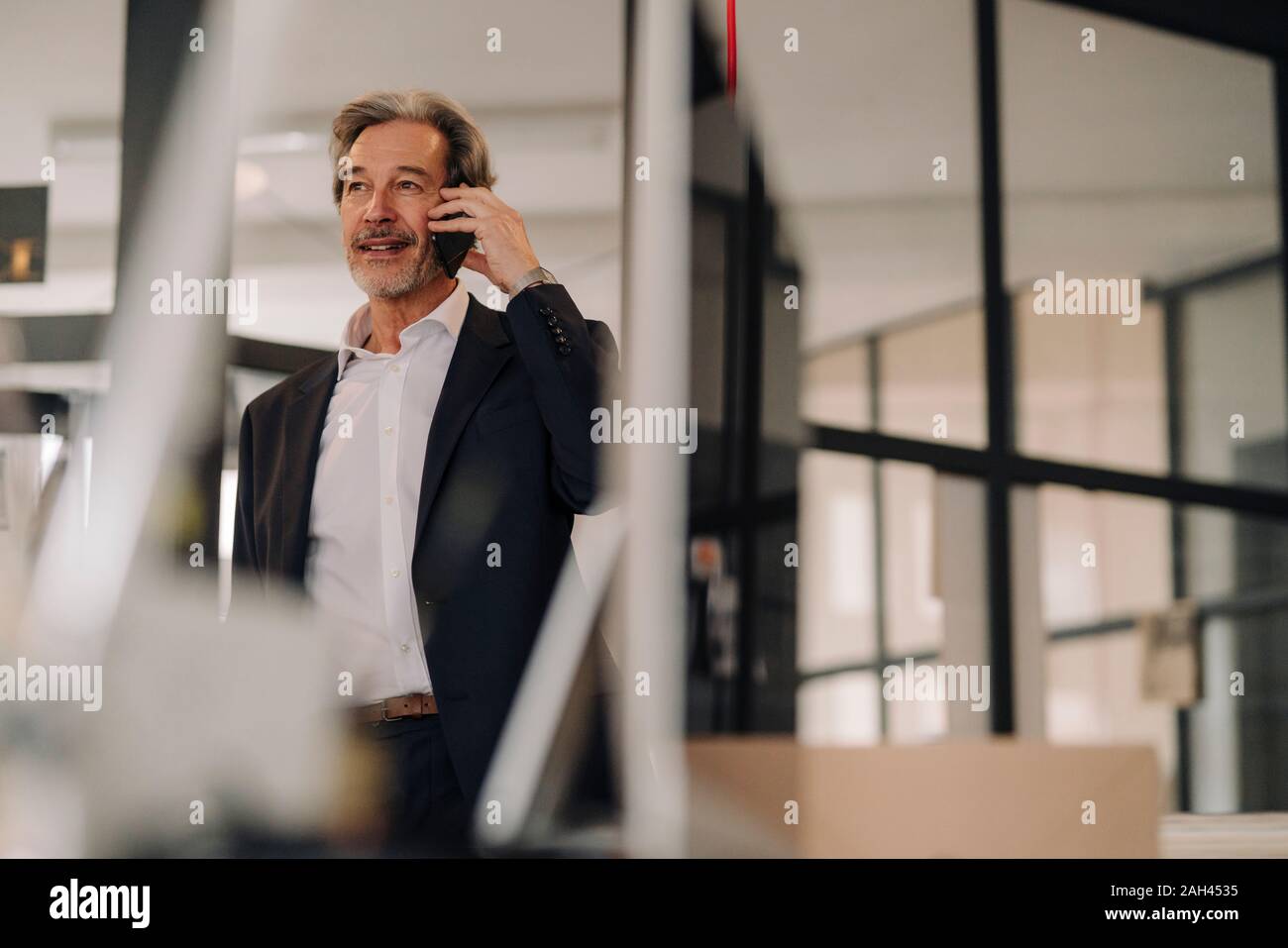 Senior Geschäftsmann am Telefon im Büro Stockfoto