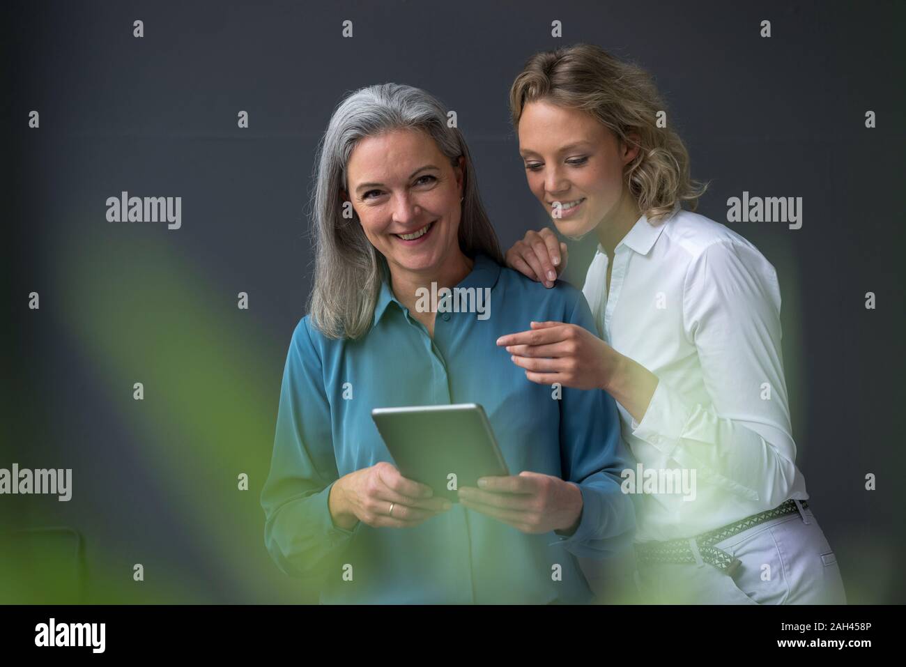 Zwei lächelnde Geschäftsfrauen in einem Tablet Stockfoto