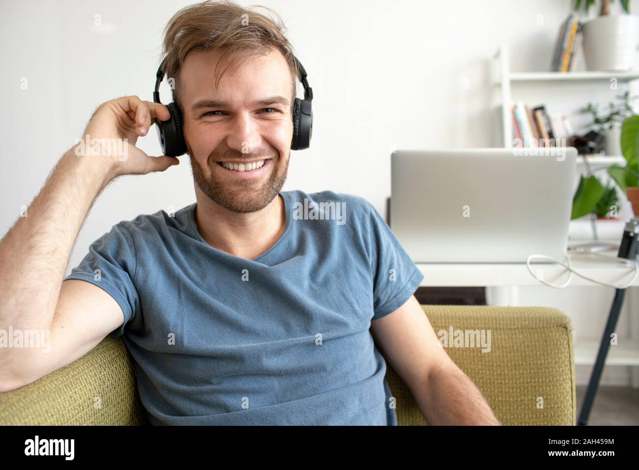 Portrait von lächelnden Mann sitzt auf der Couch im Büro Musik hören Stockfoto