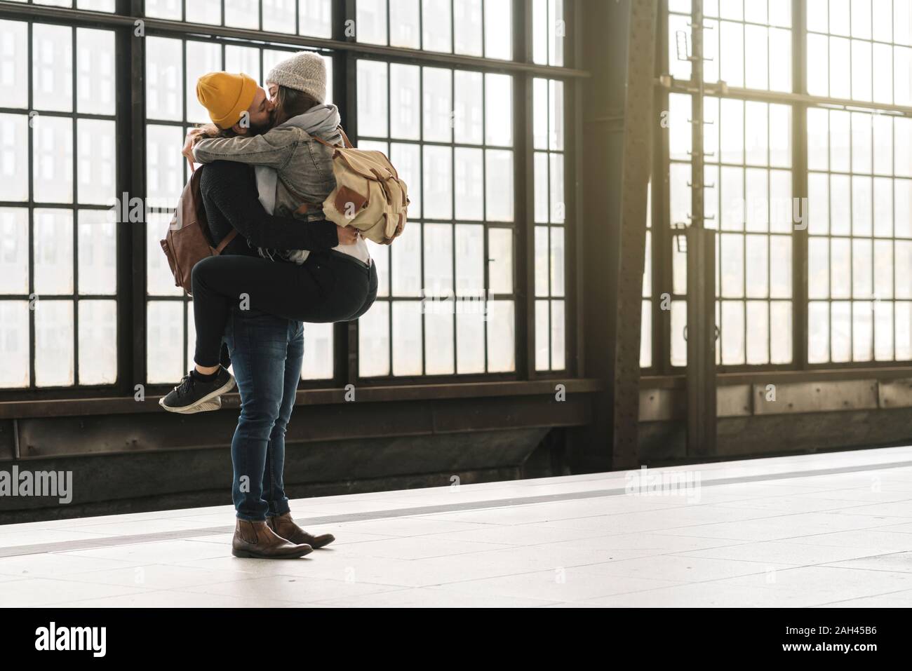 Liebevolle junge Paar küssen am Bahnsteig, Berlin, Deutschland