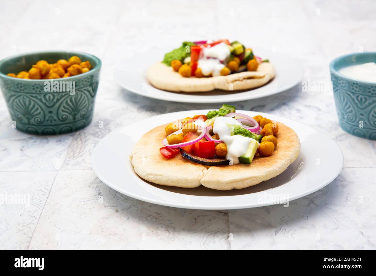 Israelische sabich mit pita Brot, Aubergine, Kichererbsen, Zwiebeln, Tomaten, Gurken, Joghurt und zhug Sauce Stockfoto