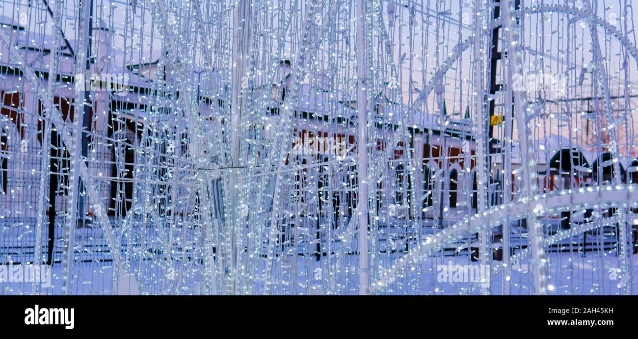 Hintergrund - Dekoration der elektrische Weihnachtsbeleuchtung an einem verschneiten Straße in den Abend close-up Stockfoto