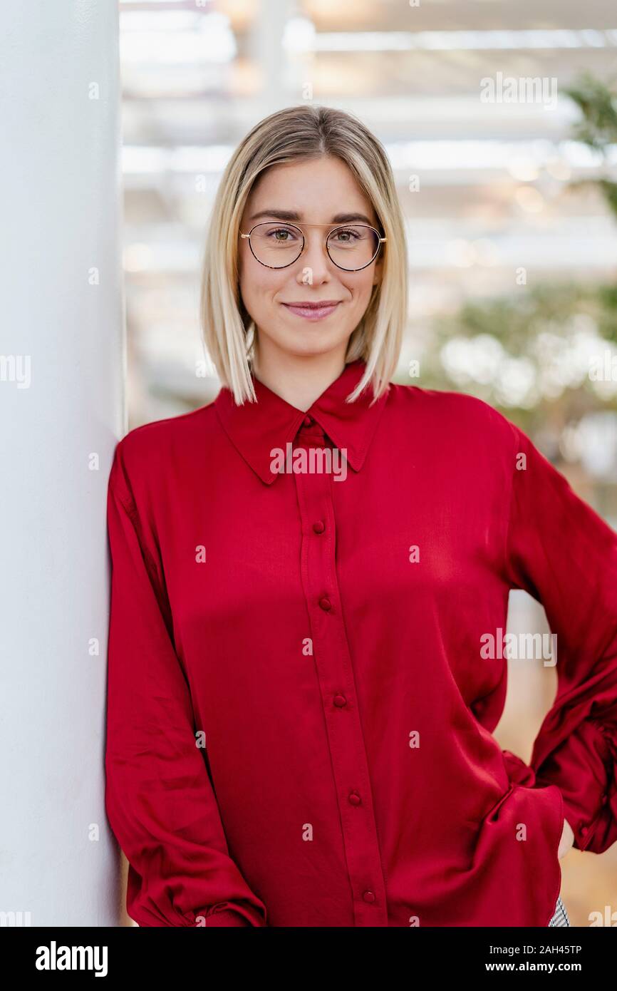 Porträt einer selbstbewussten jungen Geschäftsfrau lehnte sich gegen eine Spalte Stockfoto