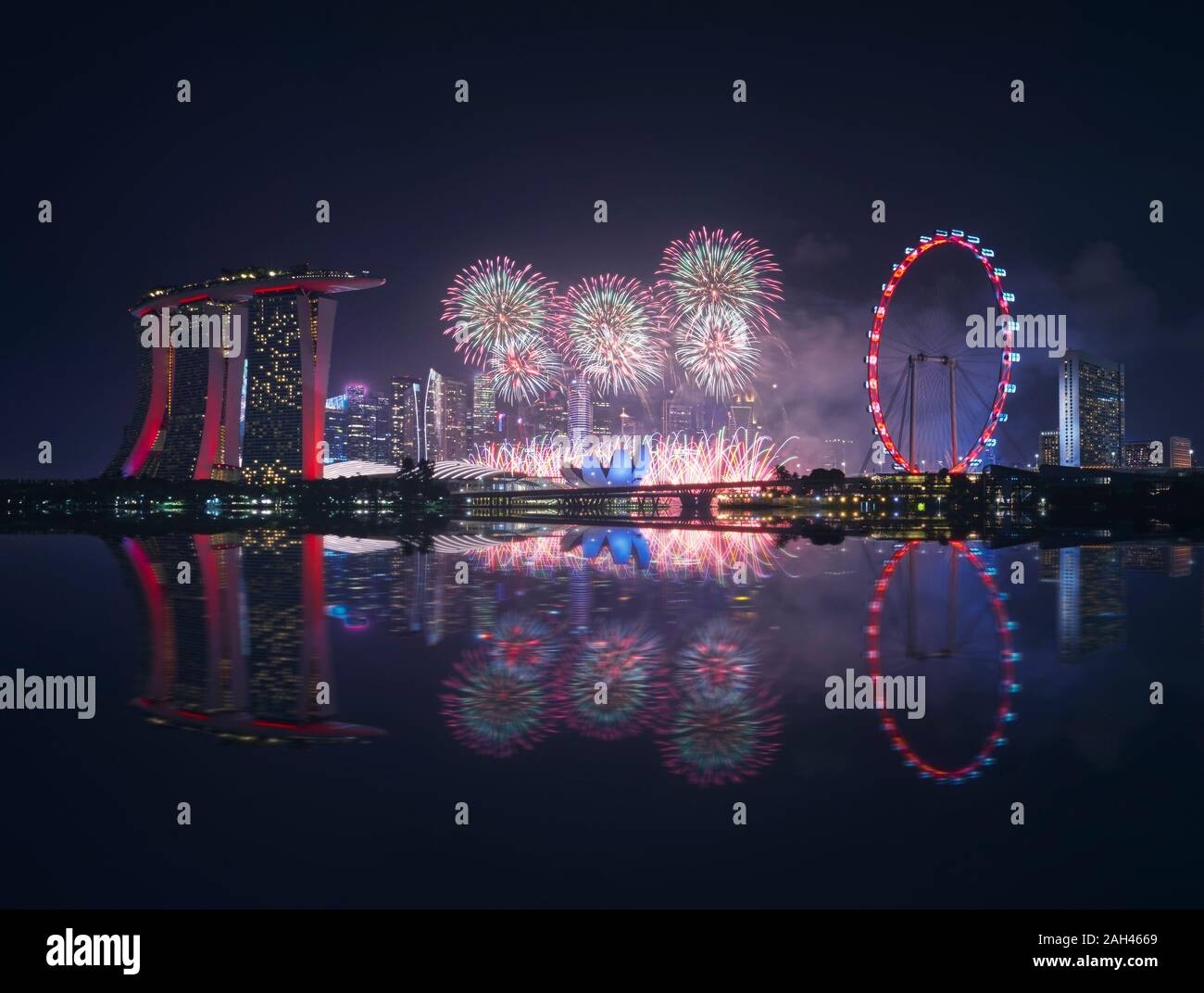 Singapur, Nacht, Feuerwerk zwischen Marina Bay Sands Hotel und beleuchtete Riesenrad Stockfoto
