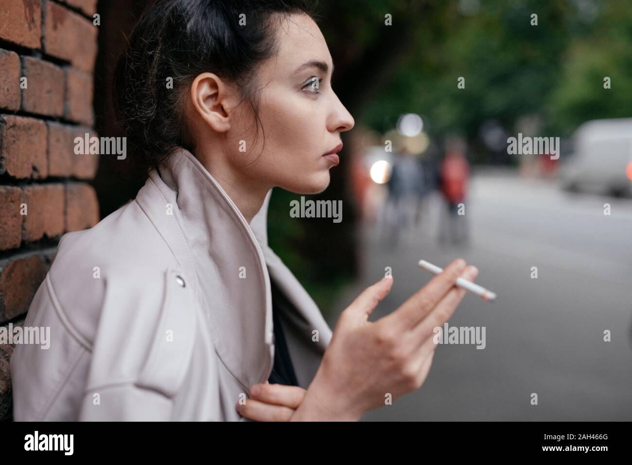 Profil von nachdenklich Frau mit Zigarette im Freien Stockfoto