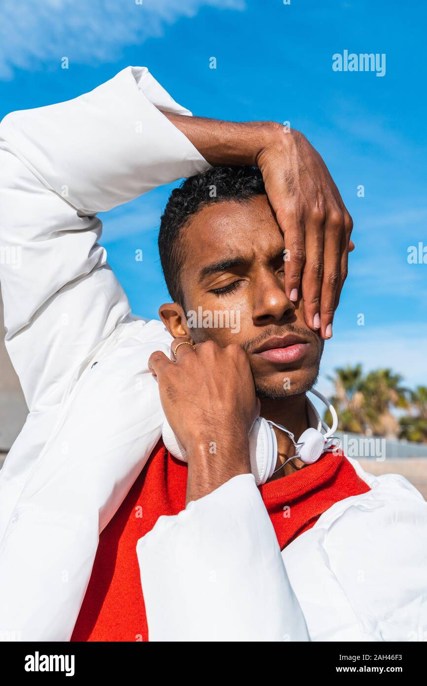 Portrait des jungen Mannes im Freien mit Händen auf dem Gesicht Stockfoto