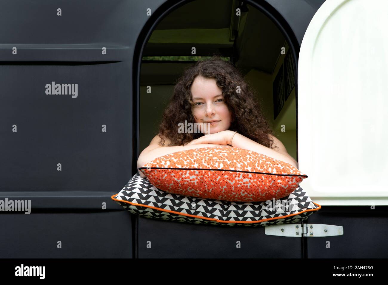 Porträt der jungen Frau Schiefen auf Kissen aus Caravan suchen Stockfoto