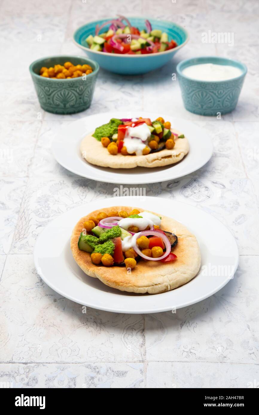 Israelische sabich mit pita Brot, Aubergine, Kichererbsen, Zwiebeln, Tomaten, Gurken, Joghurt und zhug Sauce Stockfoto