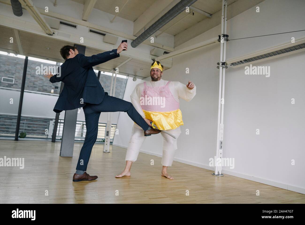 Unternehmer treten Mann verkleidet sich als Ballerina in Office Stockfoto