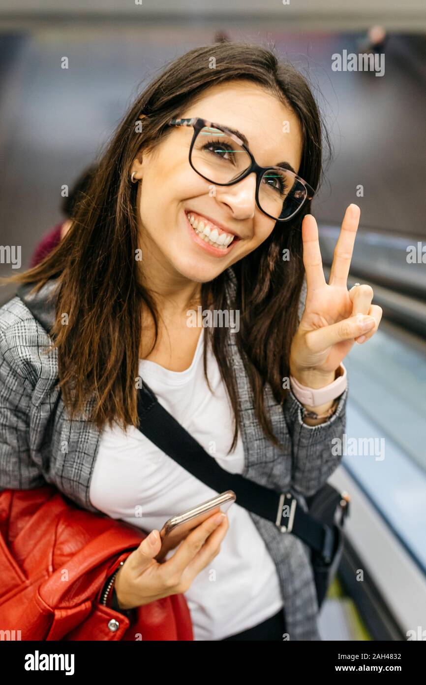 Brünette Frau, die von der Arbeit glücklich machen den Sieg Zeichen Stockfoto