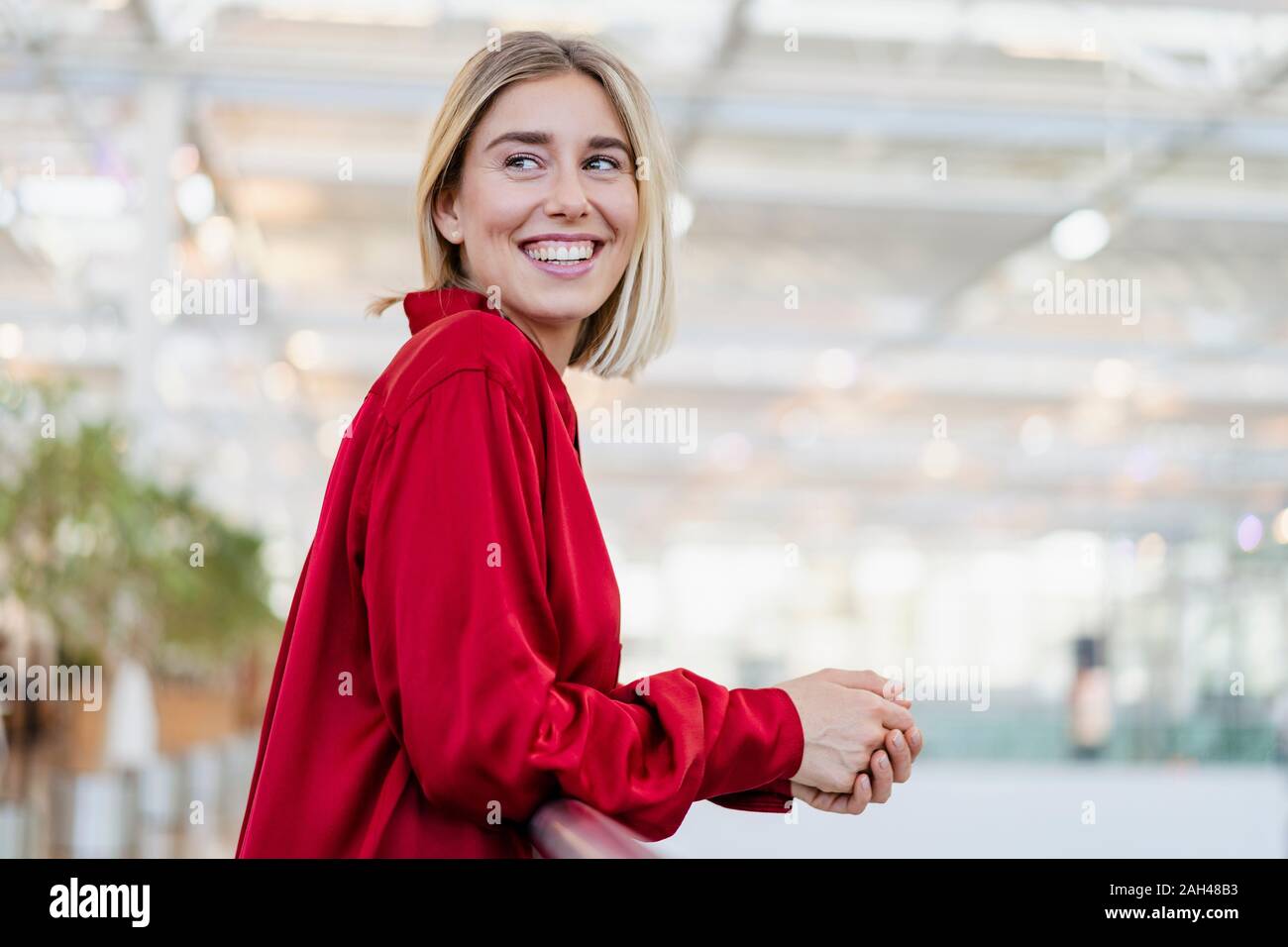 Portrait eines glücklichen jungen Geschäftsfrau stehend an einem Geländer Stockfoto