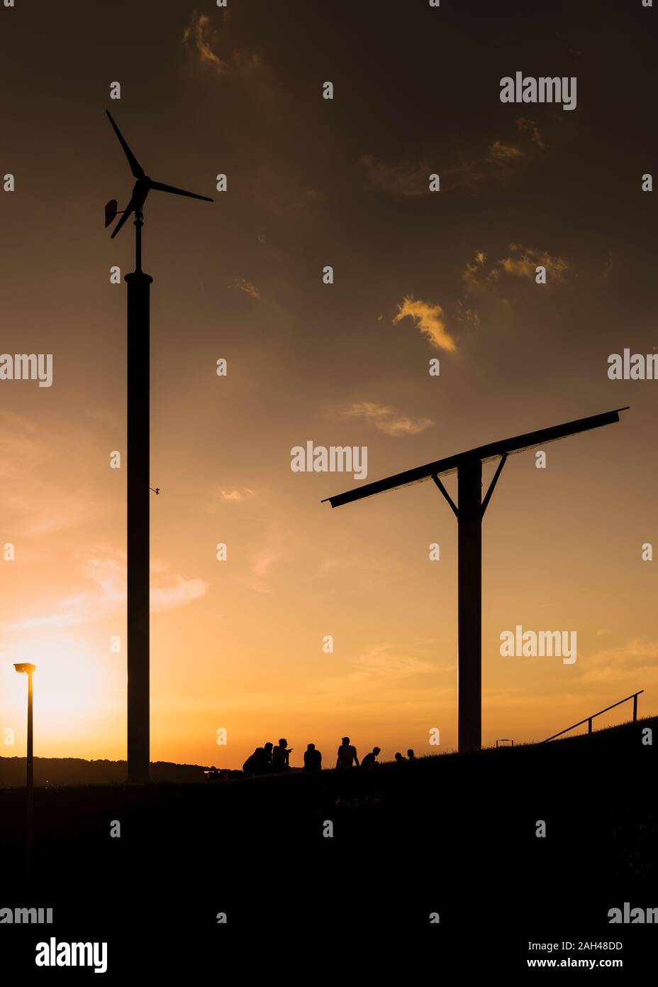 Deutschland, Wuppertal, Bergische Universität Wuppertal, wind turbine, Solar Panel und Studenten bei Sonnenuntergang Stockfoto
