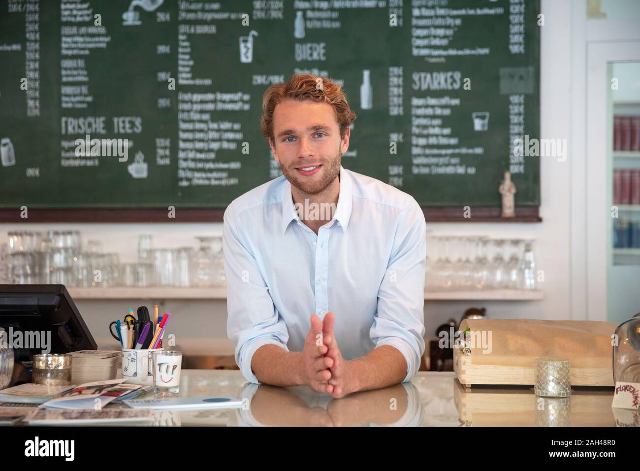 Junge Unternehmer in einem Cafe, stützte sich auf Zähler Stockfoto