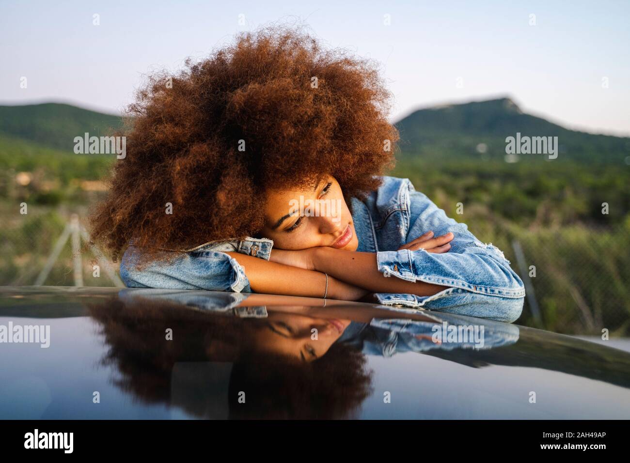 Junge Frau während der Road Trip, lehnte sich auf dem Dach Stockfoto