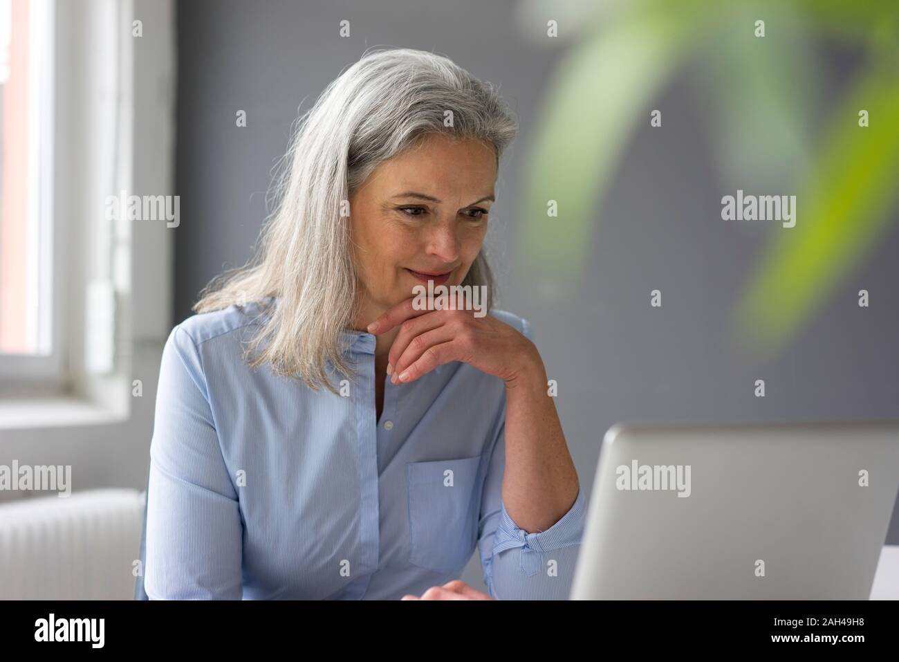 Portrait von Reife Geschäftsfrau mit Laptop im Büro Stockfoto
