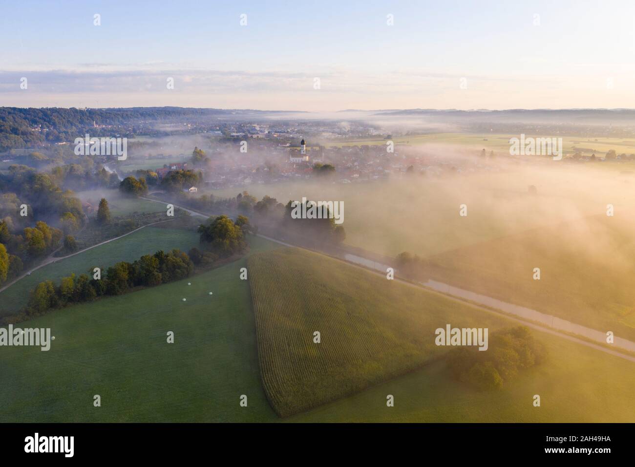 Deutschland, Bayern, Geretsried, Luftaufnahme von grünen Feldern und Loisach river canal eingehüllt in Nebel am Morgen Stockfoto