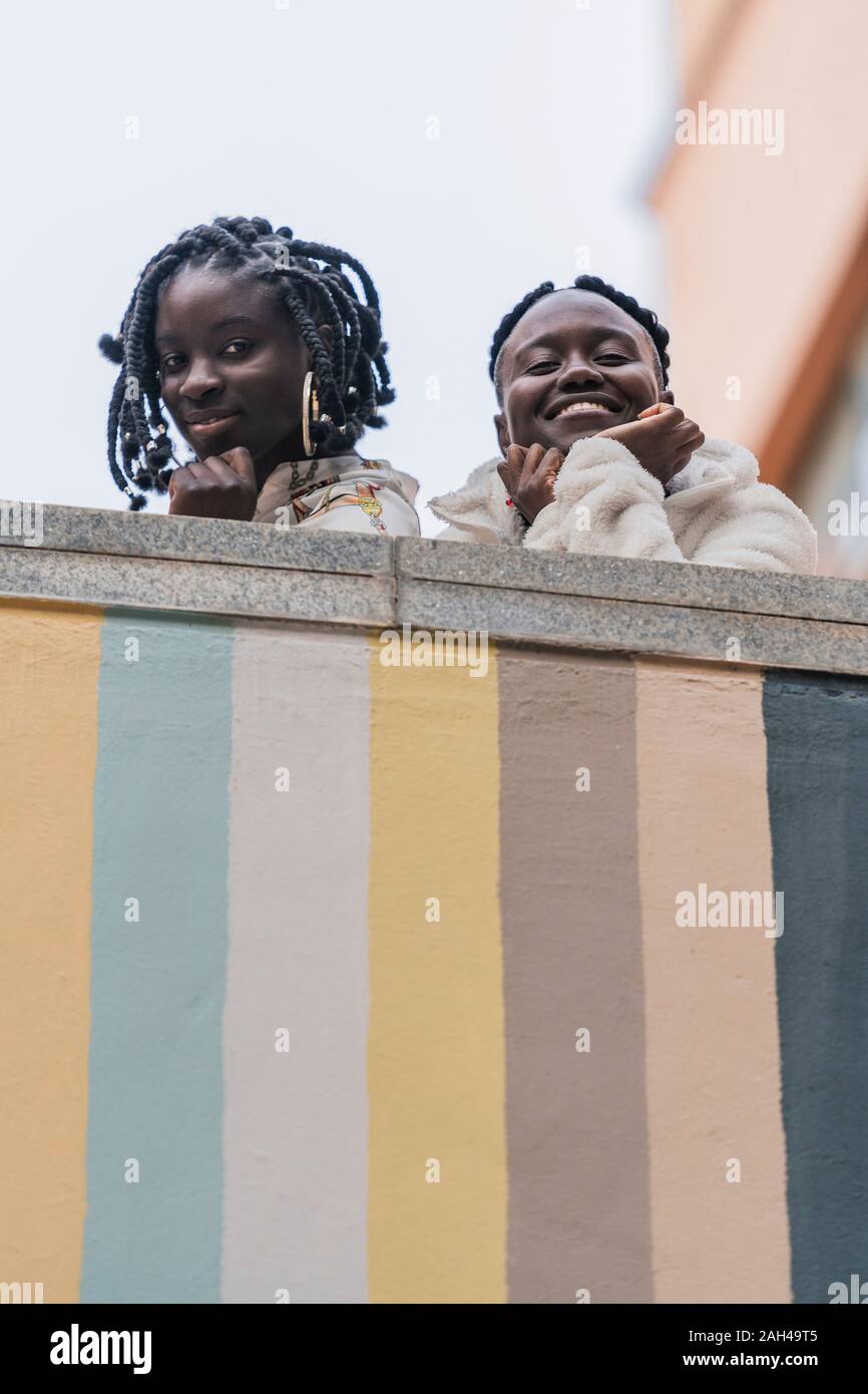 Portrait von zwei lächelnde Freunde auf Viewer lehnte sich auf Balustrade Stockfoto
