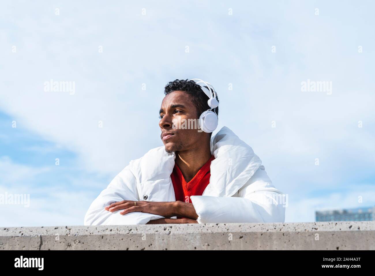 Junger Mann Musik hören mit Kopfhörern im Freien Stockfoto