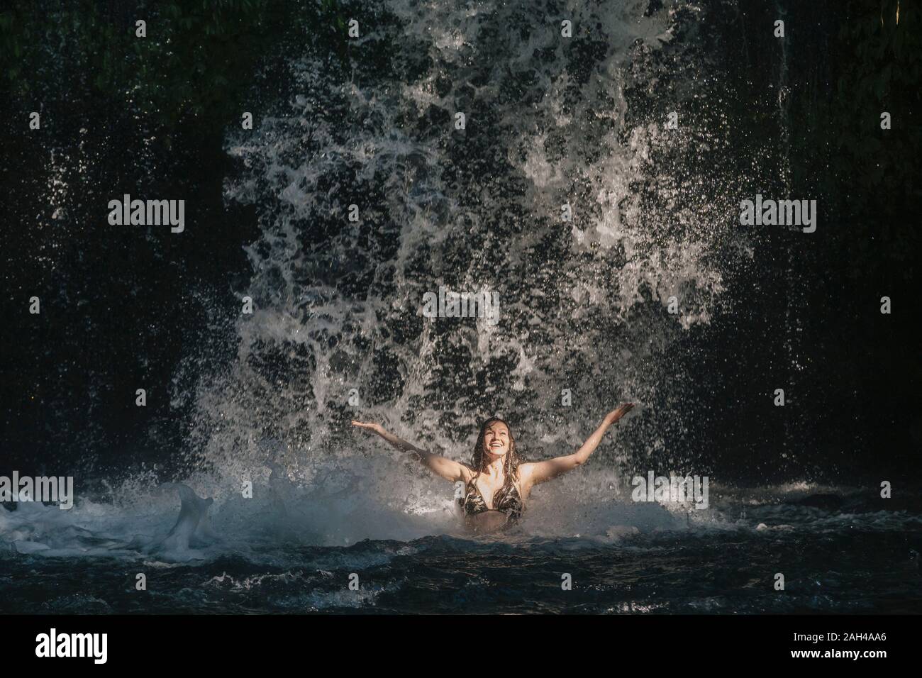 Junge Frau in der Nähe von Wasserfall, Bali, Indonesien Stockfoto