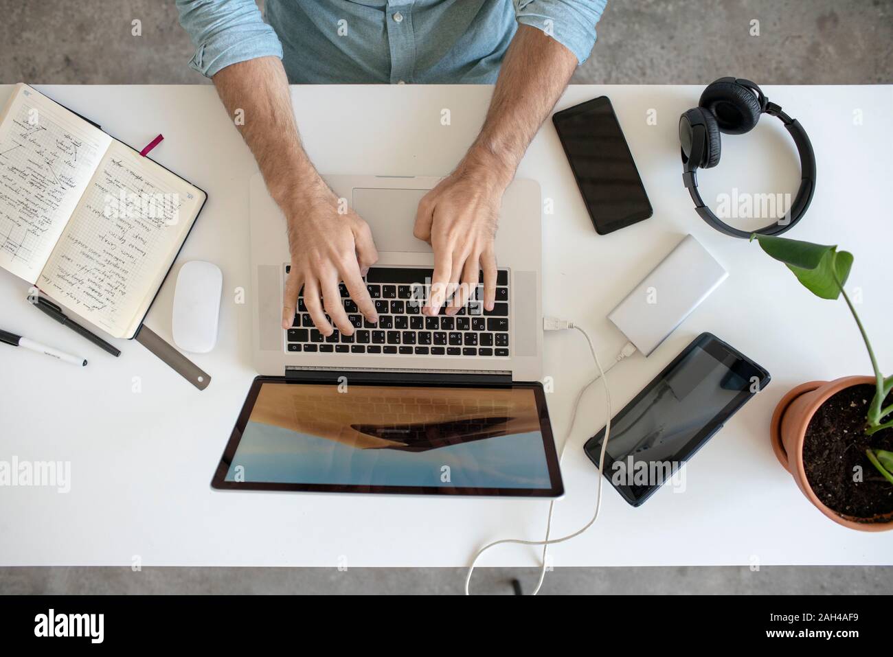 Blick von oben auf die Mann mit Laptop auf dem Schreibtisch im Büro Stockfoto