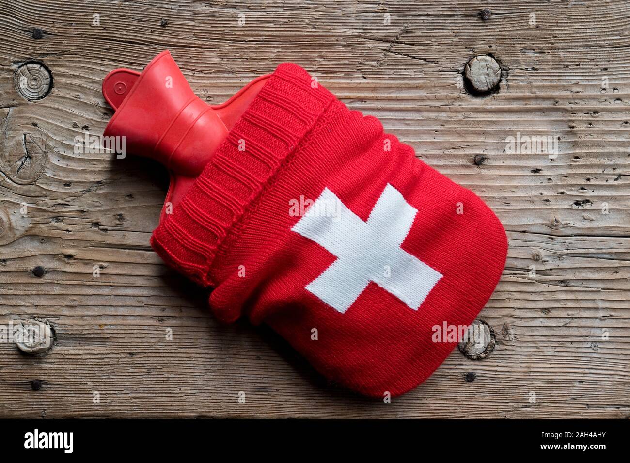 Wärmflasche auf gestrickte Ärmel mit Erste-hilfe-Symbol Stockfoto