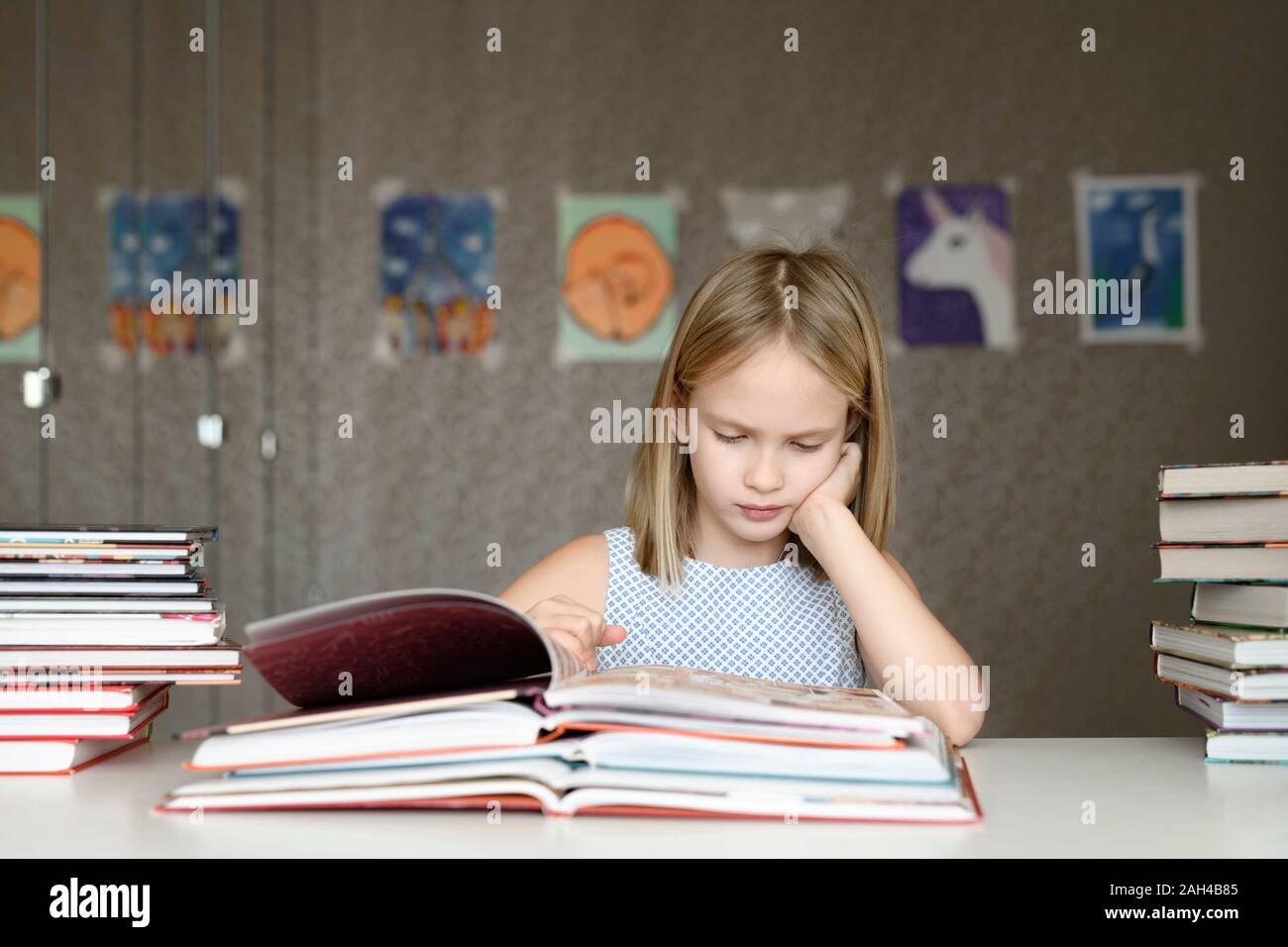 Mädchen sitzen am Tisch zu hause Bücher lesen Stockfoto