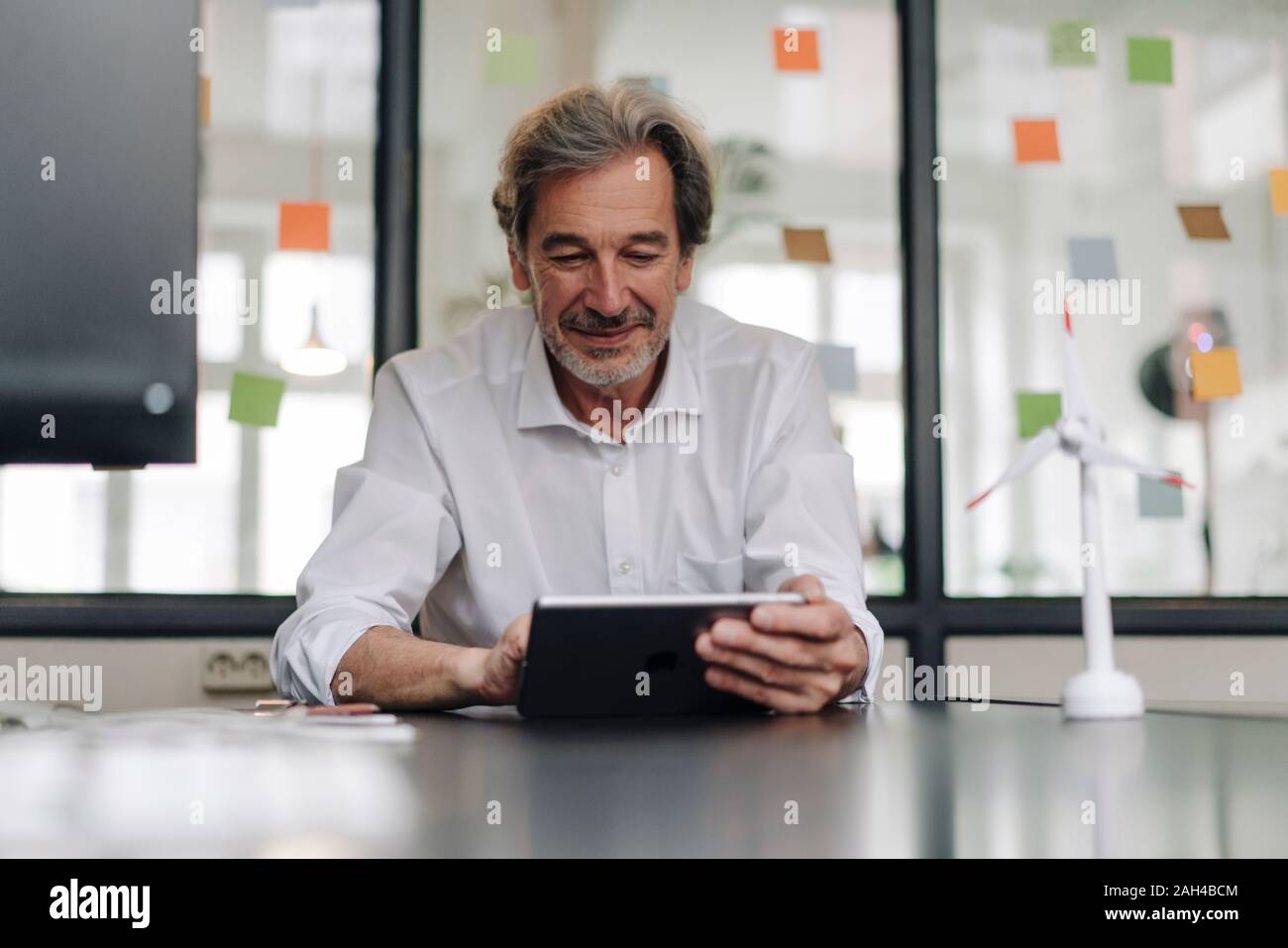Senior Geschäftsmann mit Tablette im Konferenzraum im Büro Stockfoto