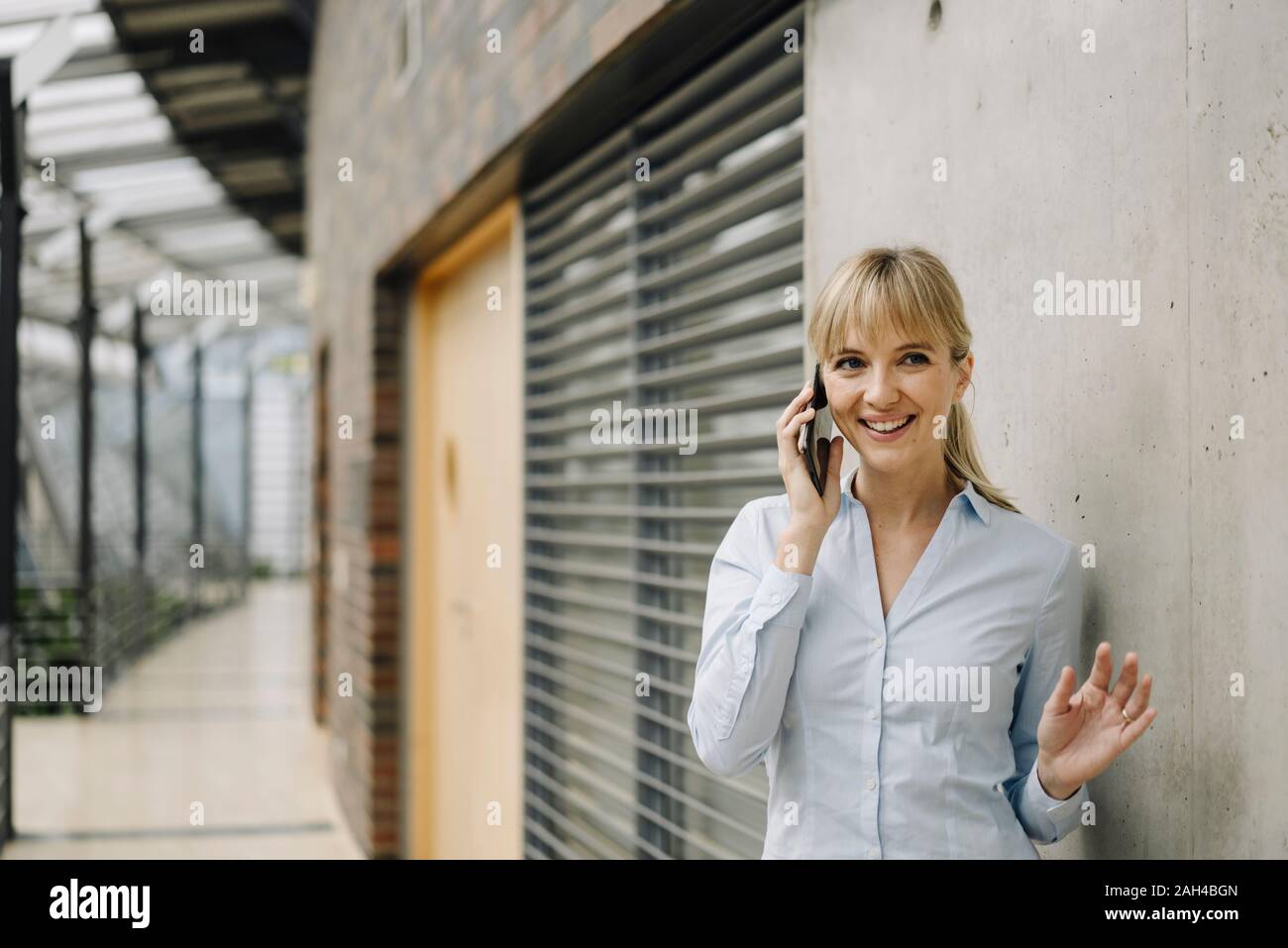 Porträt eines lächelnden Jungen geschäftsfrau am Telefon Stockfoto