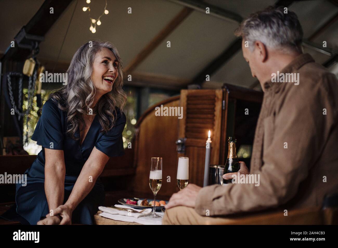 Gerne älteres Paar mit einem Candle-Light-Dinner auf einem Schiff im Bootshaus Stockfoto